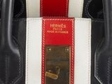 the handle of a black and white purse with a red and white stripe