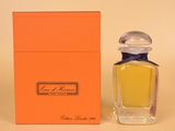 une boîte orange avec un petit flacon de parfum à côté