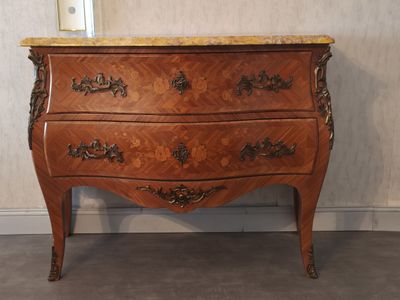 a wooden chest of drawers with a marble top