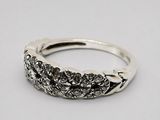 gros plan d'une bague en argent sur une surface blanche