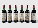 quatre bouteilles de vin sont alignées sur une surface blanche