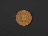 a close up of a gold coin on a black surface