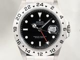 La montre Rolex possède un cadran noir et une trotteuse rouge.