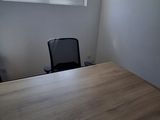 a wooden table with a black chair in front of a window