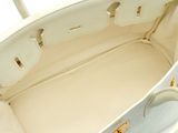 an image of a white handbag with gold hardware