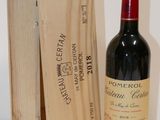 une bouteille de vin dans un coffret en bois à côté d'une bouteille de vin