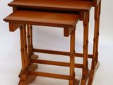 three wooden nesting tables sitting on top of each other on a white surface