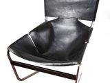 un fauteuil en cuir noir avec une structure métallique, sur fond blanc