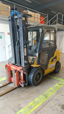 a forklift truck parked in a warehouse with a ladder