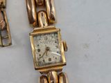an image of a gold wrist watch with a chain around it