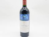 la bouteille de vin rouge est posée sur une surface blanche