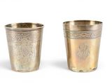 une paire de coupes en argent ornées de motifs gravés sur fond blanc