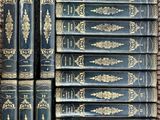 several old books are stacked on top of each other in a box