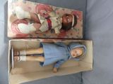 a small doll in a box with a doll in it