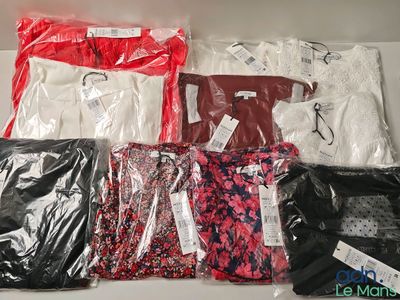 many different types of shirts in bags on a shelf