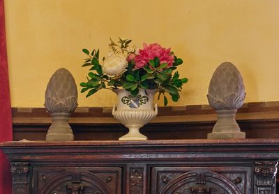 un vase de fleurs posé sur un meuble en bois