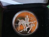 silver coin with a picture of a man on a horse in a box