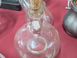 une bouteille en verre avec un bouchon en liège posée sur une table