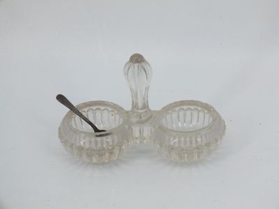 a small glass bowl with a spoon in it on a white surface