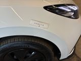 a close up of a white car with a sticker on it