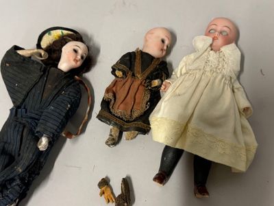 trois poupées posées les unes à côté des autres sur une table