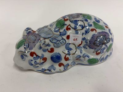 une figurine représentant un chat, ornée de fleurs et d'oiseaux