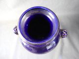 a blue vase that is sitting on a white surface