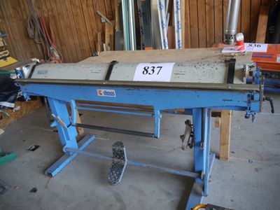 une table bleue sur laquelle est posée une étiquette de prix, dans un garage