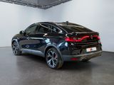 the rear end of a black suv parked in a showroom