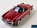 a red toy car that is sitting on a white surface