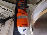 an orange and black electric drill sitting on top of a table next to a book