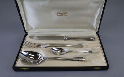 a silverware set in a case with a spoon, fork and spoon rest