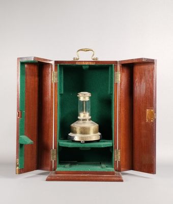 une petite boîte en bois contenant un objet en laiton