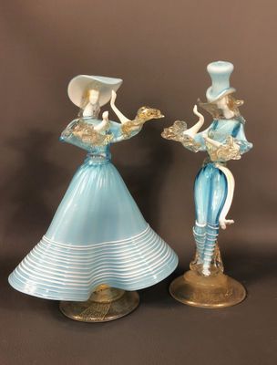 pair of blue glass figurines of ladies with hats and tails