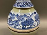 a blue and white vase with a lid on a table