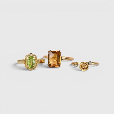 un lot de trois bagues et une bague sertie d'une pierre verte
