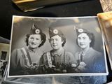 a black and white photo of three women wearing hats