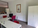 a white desk with a red chair and a computer on it