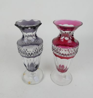 two glass vases sitting side by side on a white surface