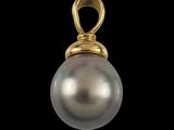 a close up of a pearl pendant on a black background
