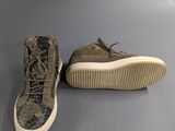 a pair of camouflage shoes on a gray surface