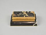a black and gold box with a flower design on it