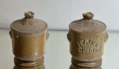 two brown vases sitting on a glass table