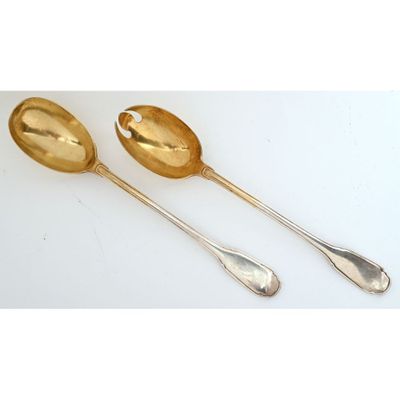 two spoons and a spoon rest on a white surface