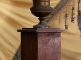 a small vase sitting on top of a wooden pillar