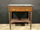 an old wooden table with a marble top on a wooden floor