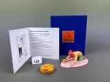a miniature figurine of a man on a surfboard next to a book