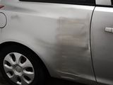 a silver car with a dirty paint job on the side of it