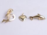two gold dolphins and a heart charm on a white background