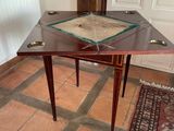 a small table with a glass top on a tile floor